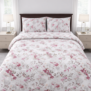 Floral bedding set on a bed in a bedroom with nightstands and lamps.