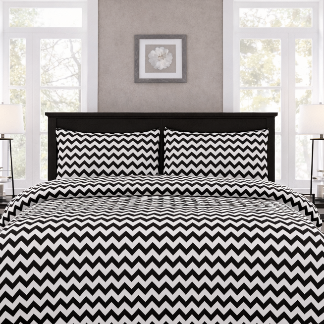 Bed with black and white zigzag patterned bedding in a bedroom setting.