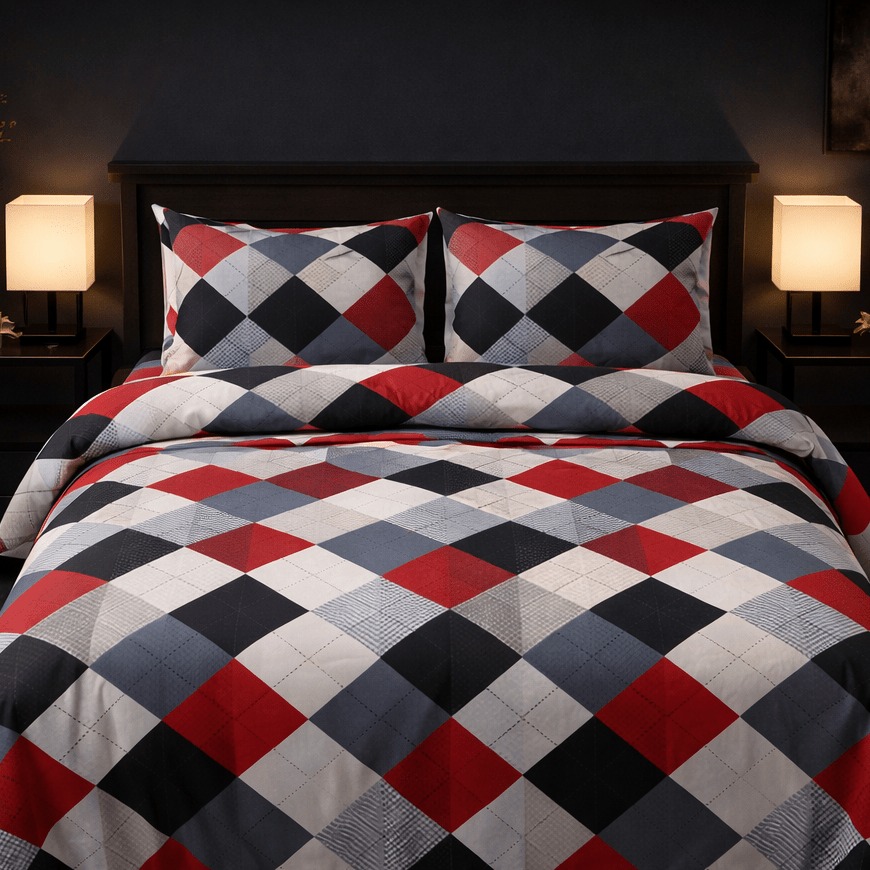 Checkered quilt with red, blue, and white pattern on a bed in a dimly lit room.