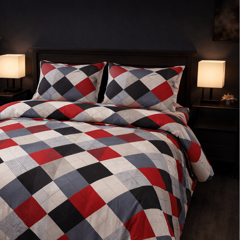 Checkered quilt and pillows on a bed in a dimly lit room with two lamps.