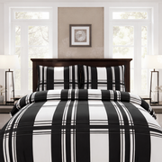 Black and white plaid bedding set on a bed in a bright bedroom.