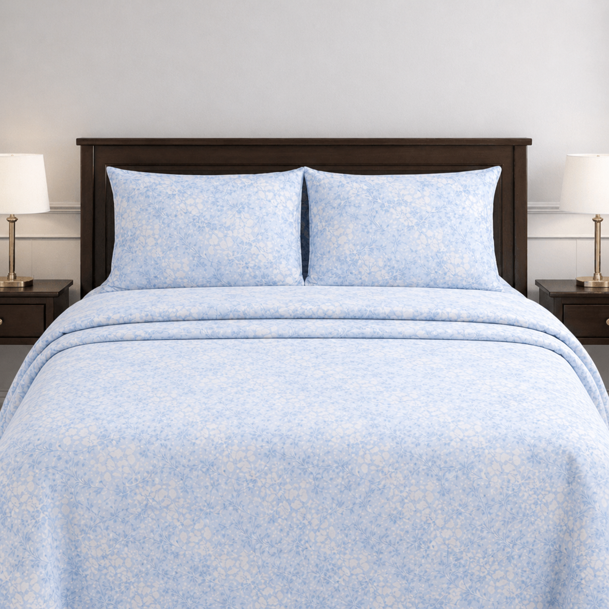 Blue floral patterned bedding set on a bed with matching pillows.