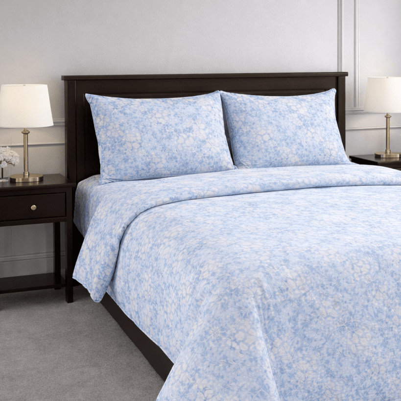 Blue floral patterned bedding set on a bed in a bedroom setting.