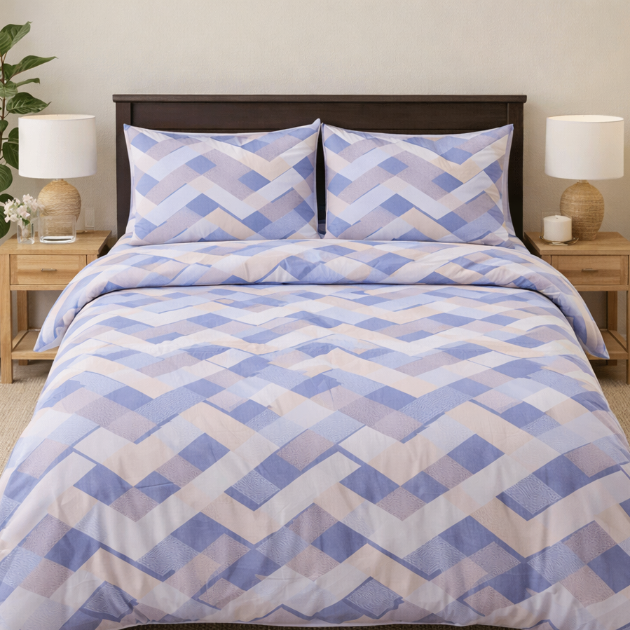 Bed with blue and white geometric patterned bedding, flanked by two nightstands with lamps.