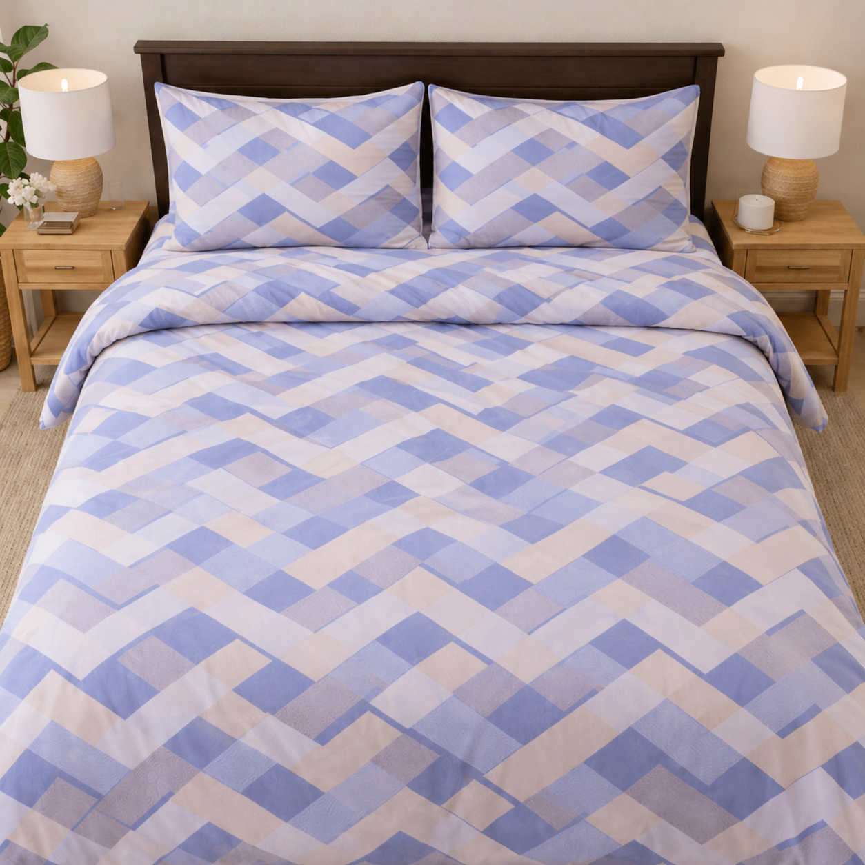 Bed with blue and beige geometric patterned bedding, flanked by two nightstands with lamps.
