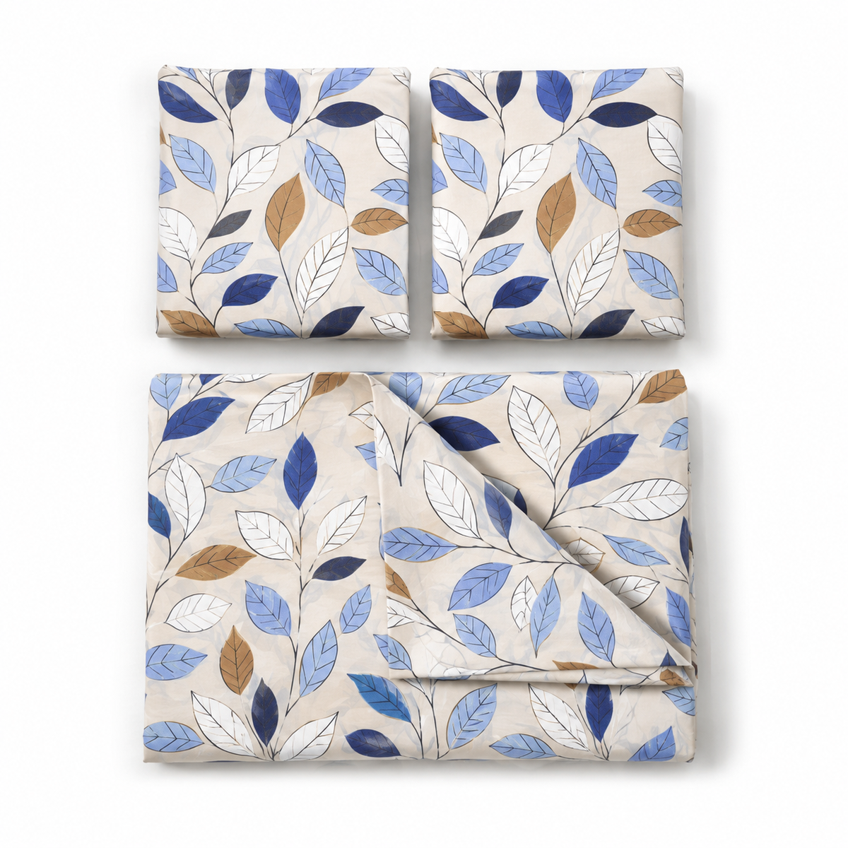 Three folded fabric pieces with a botanical leaf pattern in blue, navy, white, and tan on a light beige background, arranged on a white studio background.