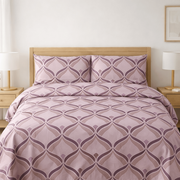 Bed with purple patterned bedding in a bedroom setting