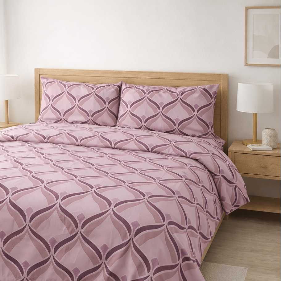 Bed with pink geometric patterned bedding in a bedroom setting.