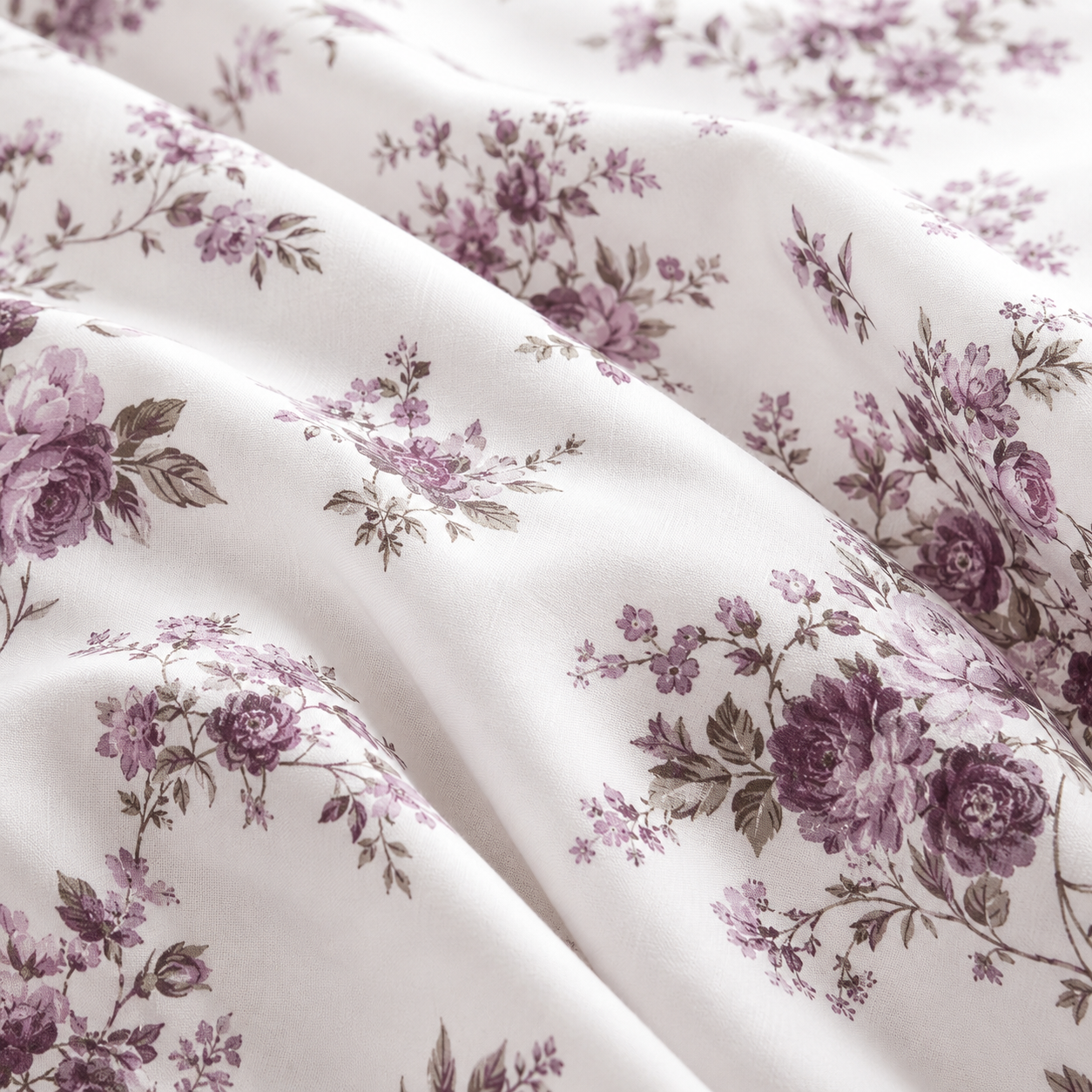 Floral patterned bedding set on a bed in a bedroom with nightstands and lamps.