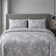Floral patterned bedding set on a bed in a bedroom setting.