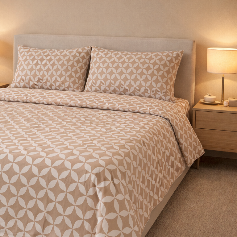 Bedroom with a bed featuring a beige and white bedding set, next to a nightstand with a lamp.