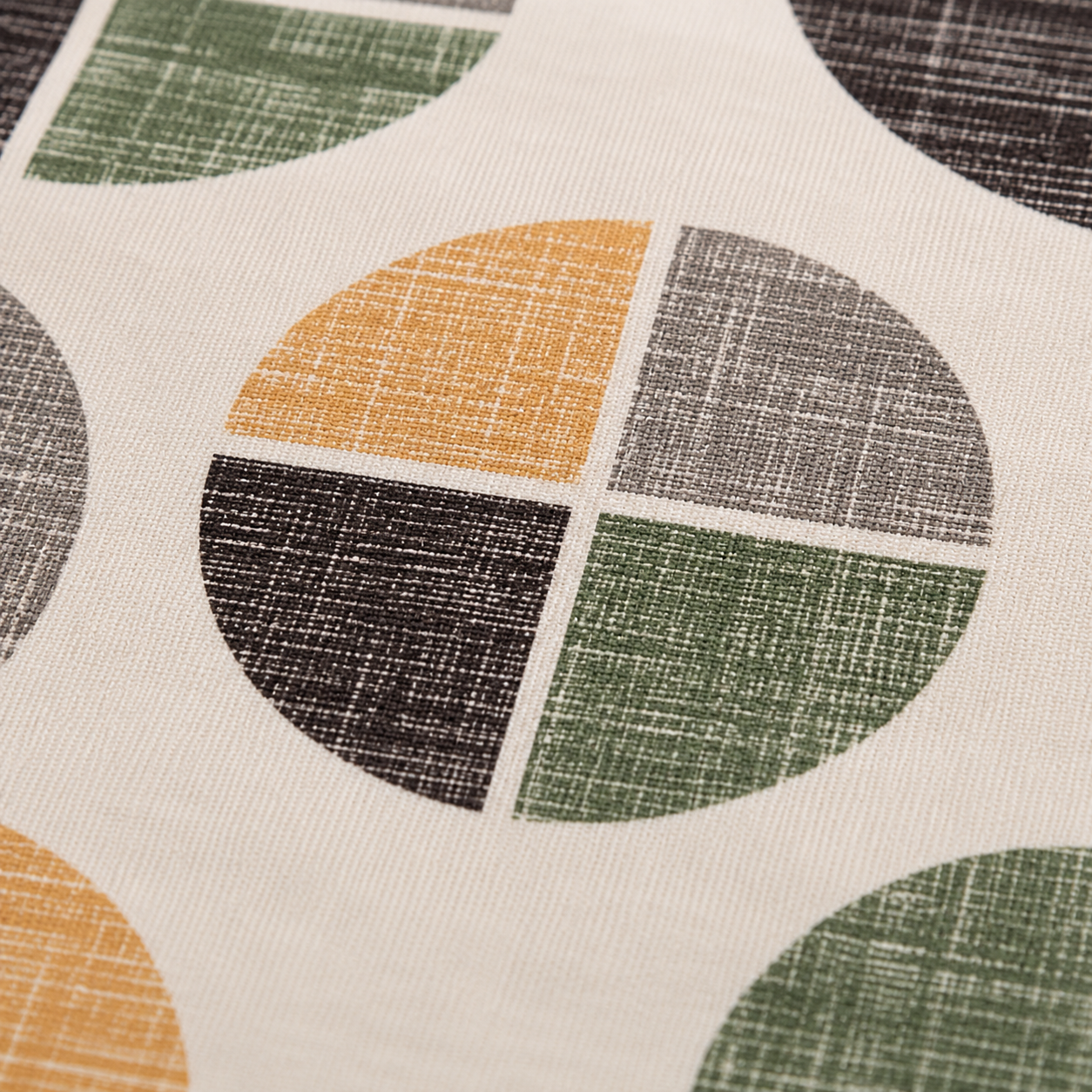 A close-up of a fabric surface with a repeating geometric pattern of partial circles on an off-white background. The visible colors in the pattern are mustard yellow, olive green, charcoal gray, and dark brown/black, with a linen-like texture.