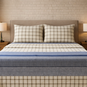 Bed with plaid bedding in a bedroom setting with lamps and decor.