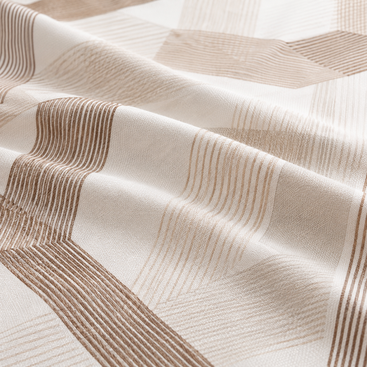 A close-up of draped fabric with a geometric pattern in warm beige and brown stripes on an off-white base.