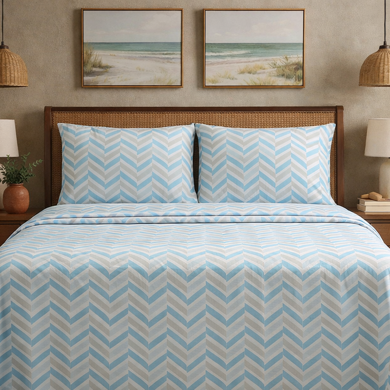 Bed with blue and white chevron patterned bedding in a room with beach-themed wall art.