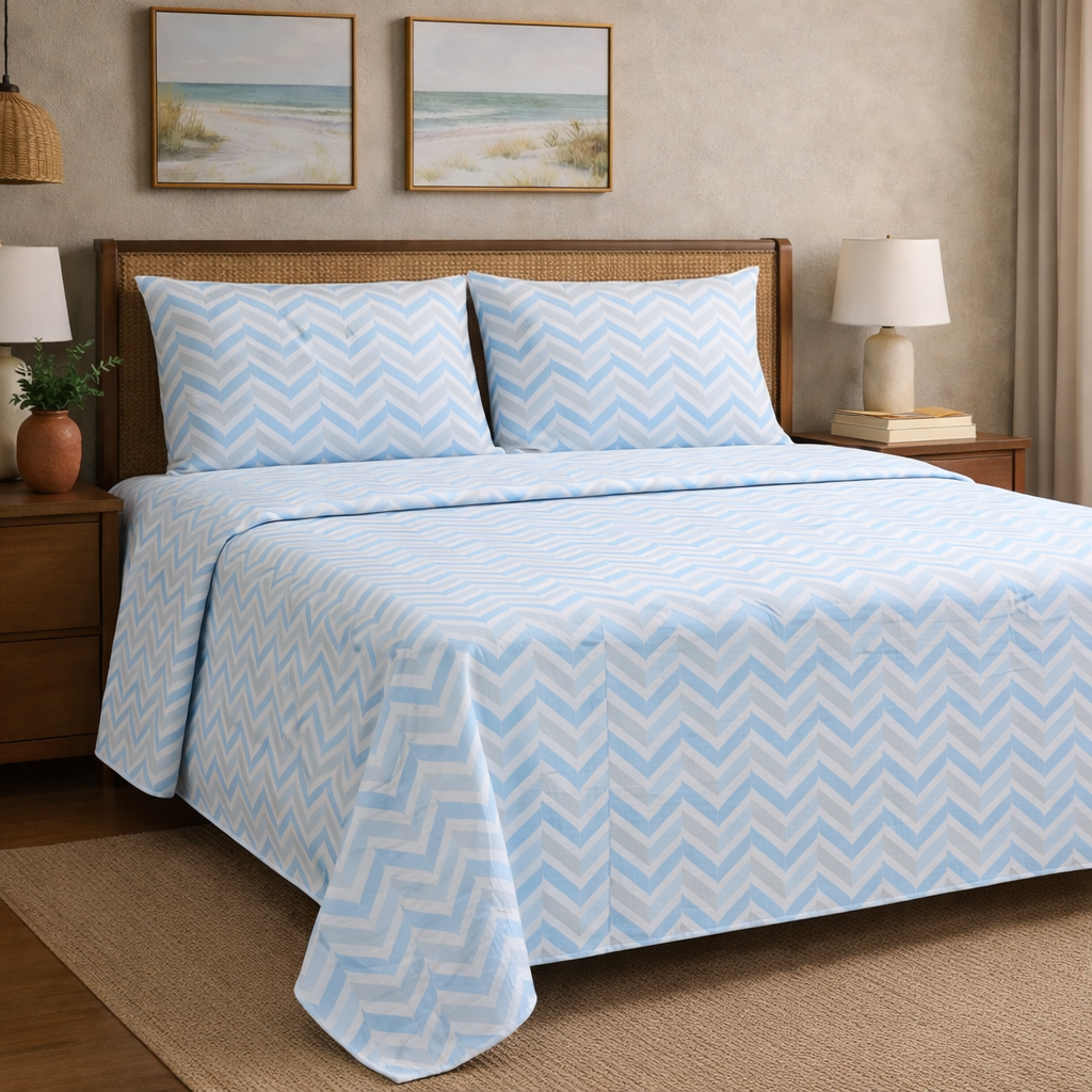 Bed with blue and white zigzag patterned bedding in a bedroom setting.