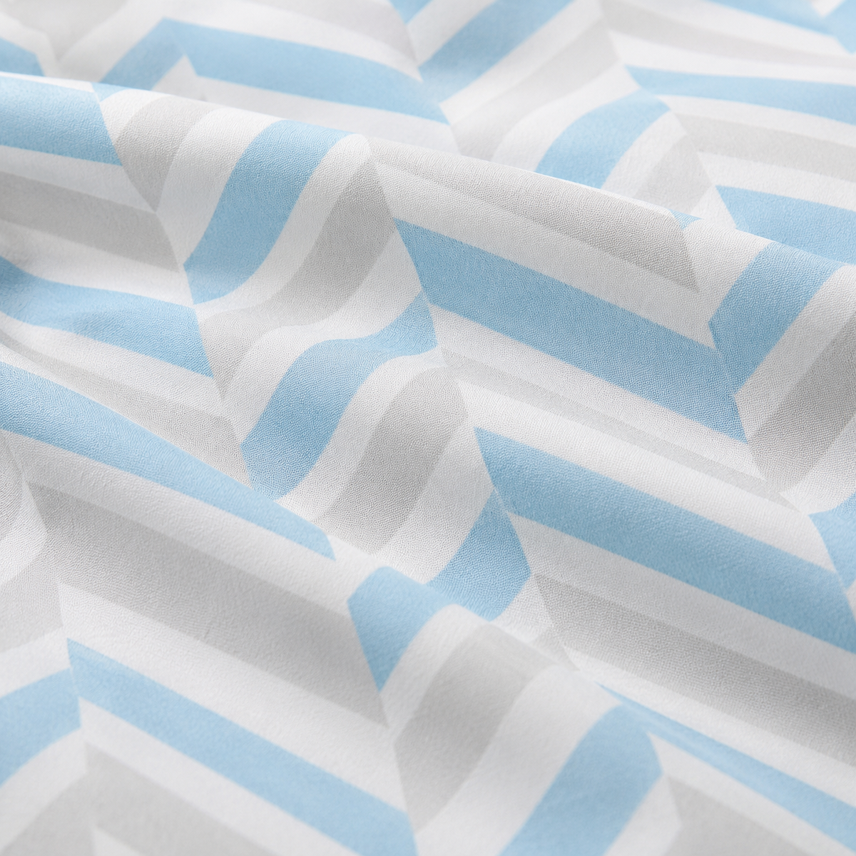 A close-up of a lightweight fabric with a repeating geometric pattern of light blue and white wavy stripes.