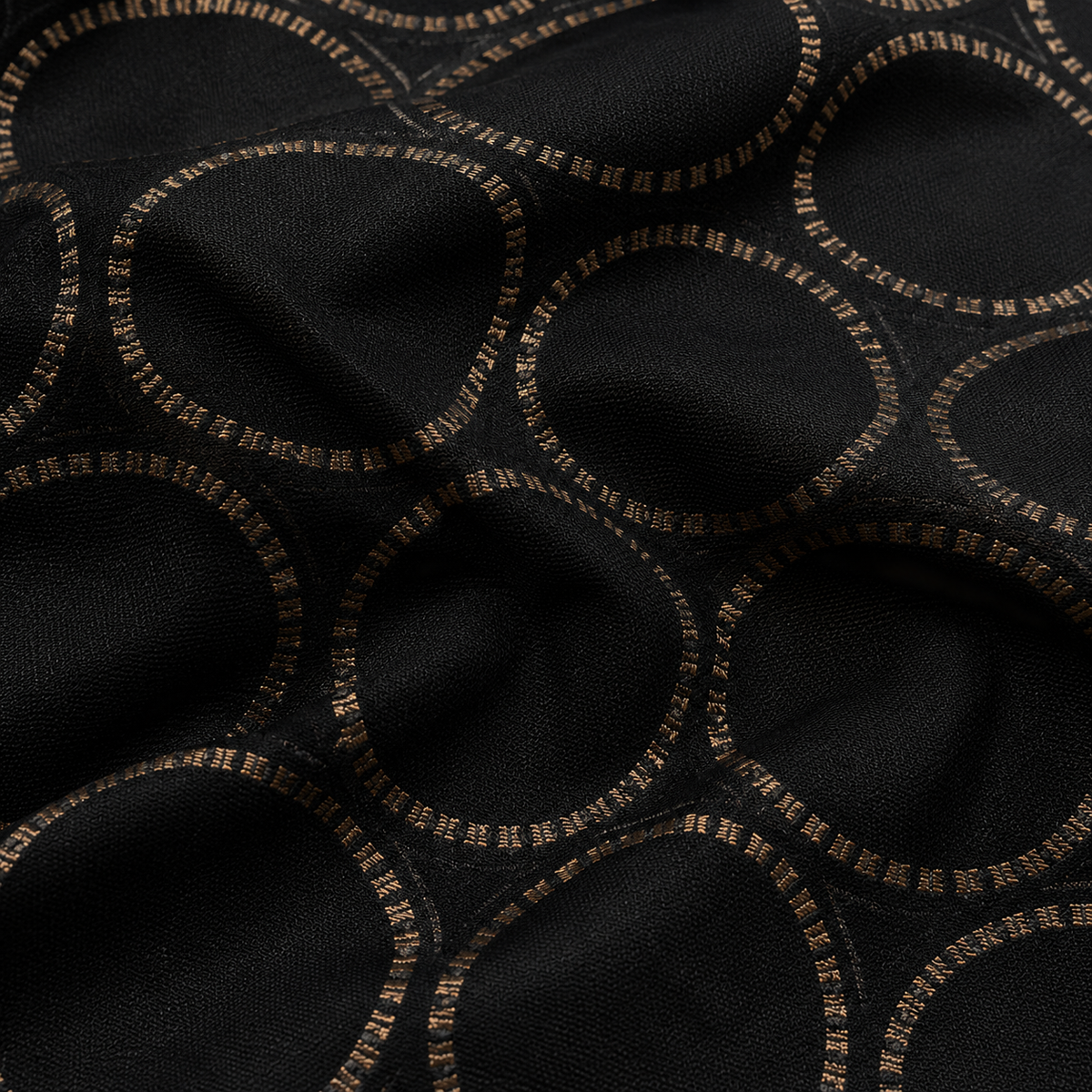 Black fabric with a repeating circular pattern outlined in metallic gold thread.