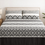 Bed with geometric patterned bedding in a bedroom setting